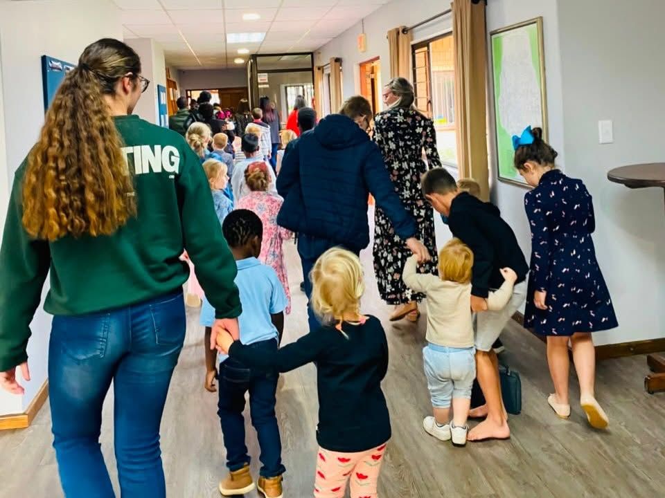 Sunday school helpers walking hand in hand with young children